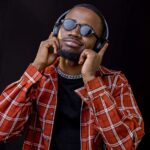 a man wearing sunglasses and a plaid shirt is listening to headphones